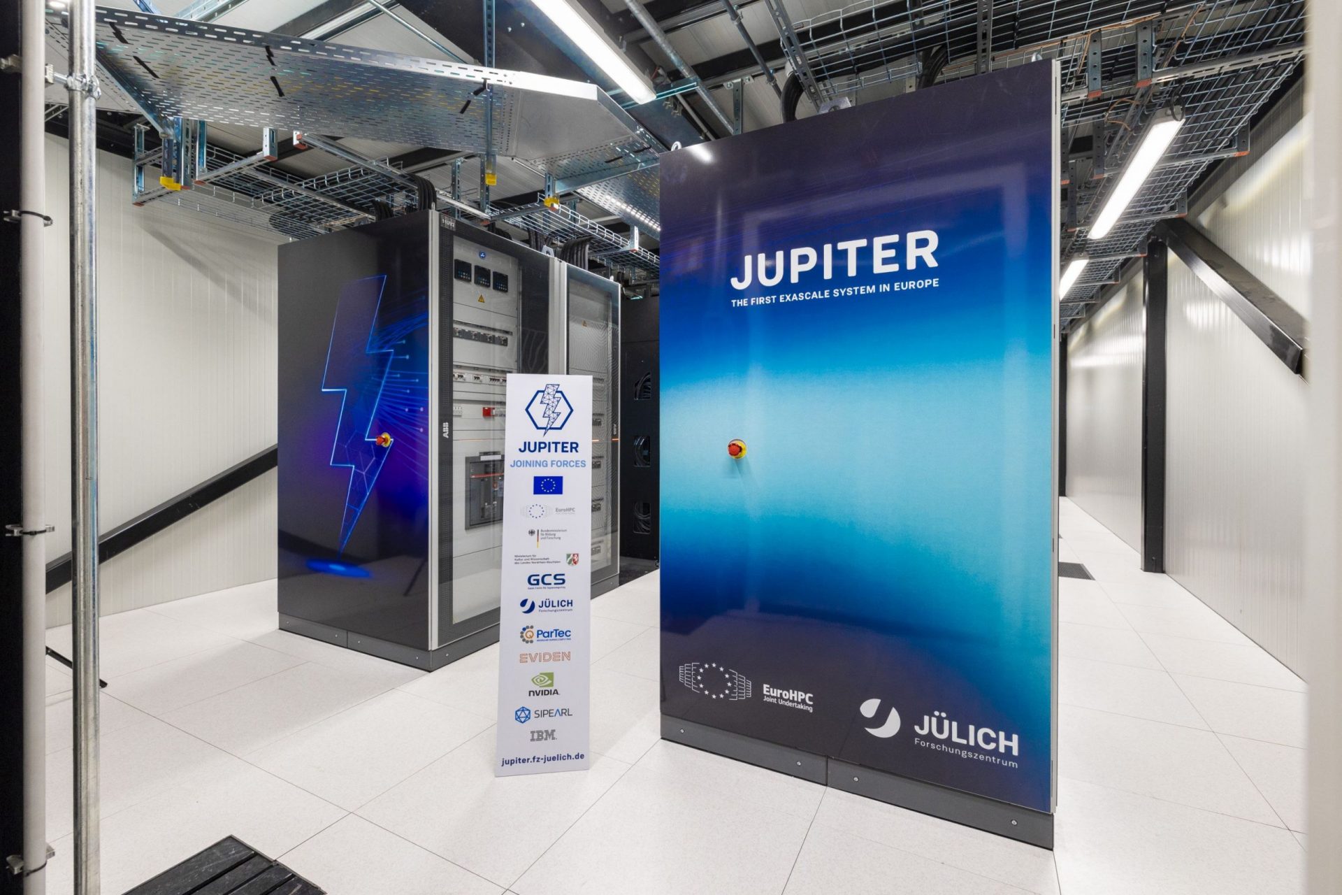 La guerra del cerebro digital: la simulación neuronal y su precio 3 https://zurired.es/wp-content/uploads/JUPITER_racks_with_logos_of_supporters_and_partners._Copyright-_Forschungszentrum_JC3BClich_-_Sascha_Kreklau-scaled.jpg